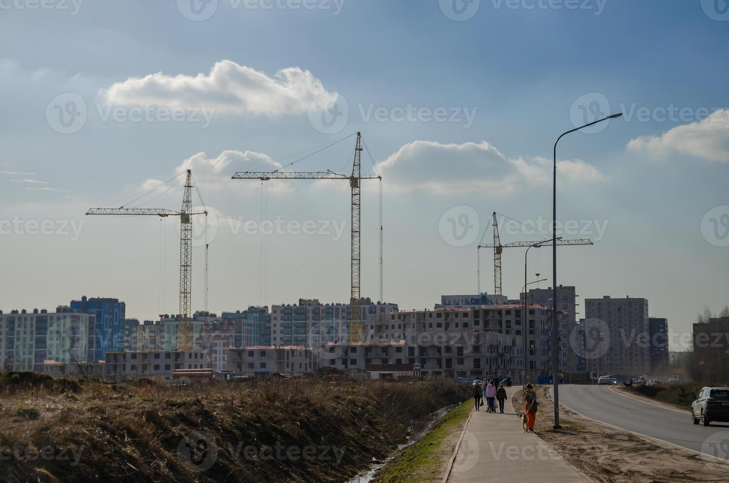 Urban construction of buildings, cranes on the background of the sky photo
