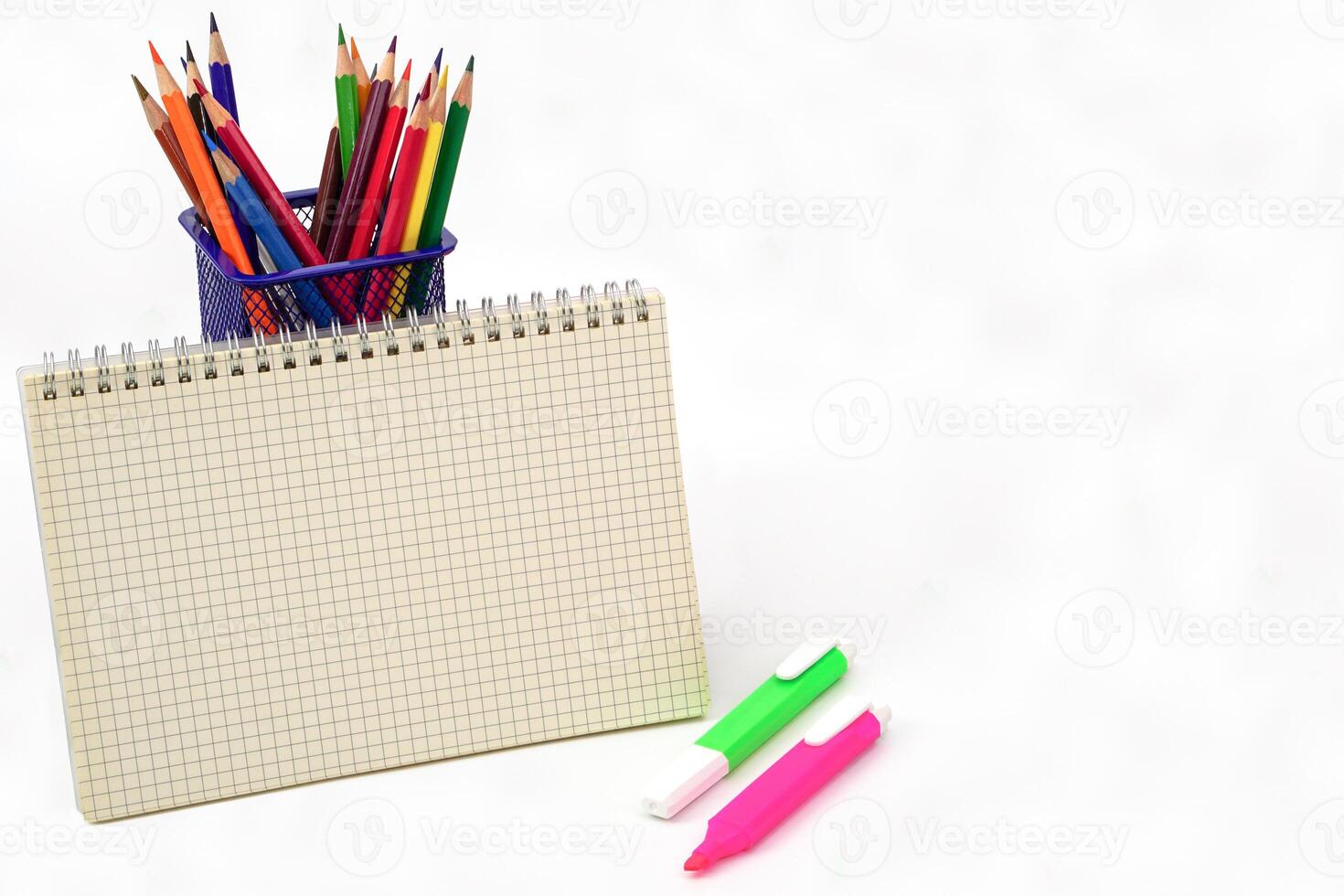 Crayon or colored pencils in box and graph book on white background. Learning, study and presentation concept. photo