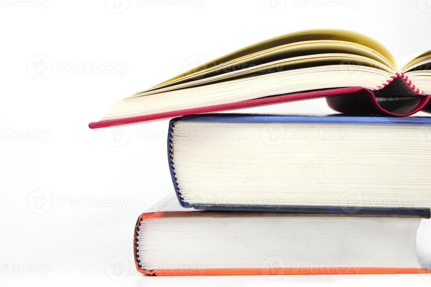 Stack of books with open book on white background. Knowledge and education concept. photo