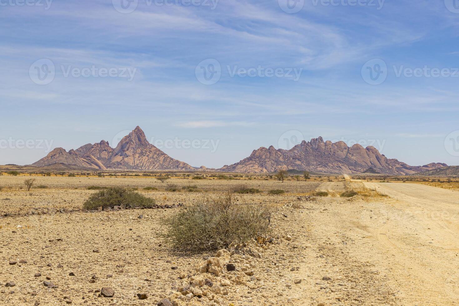 Panoramic picture of the Spitzkoppe in Namibia during the day against a blue sky photo