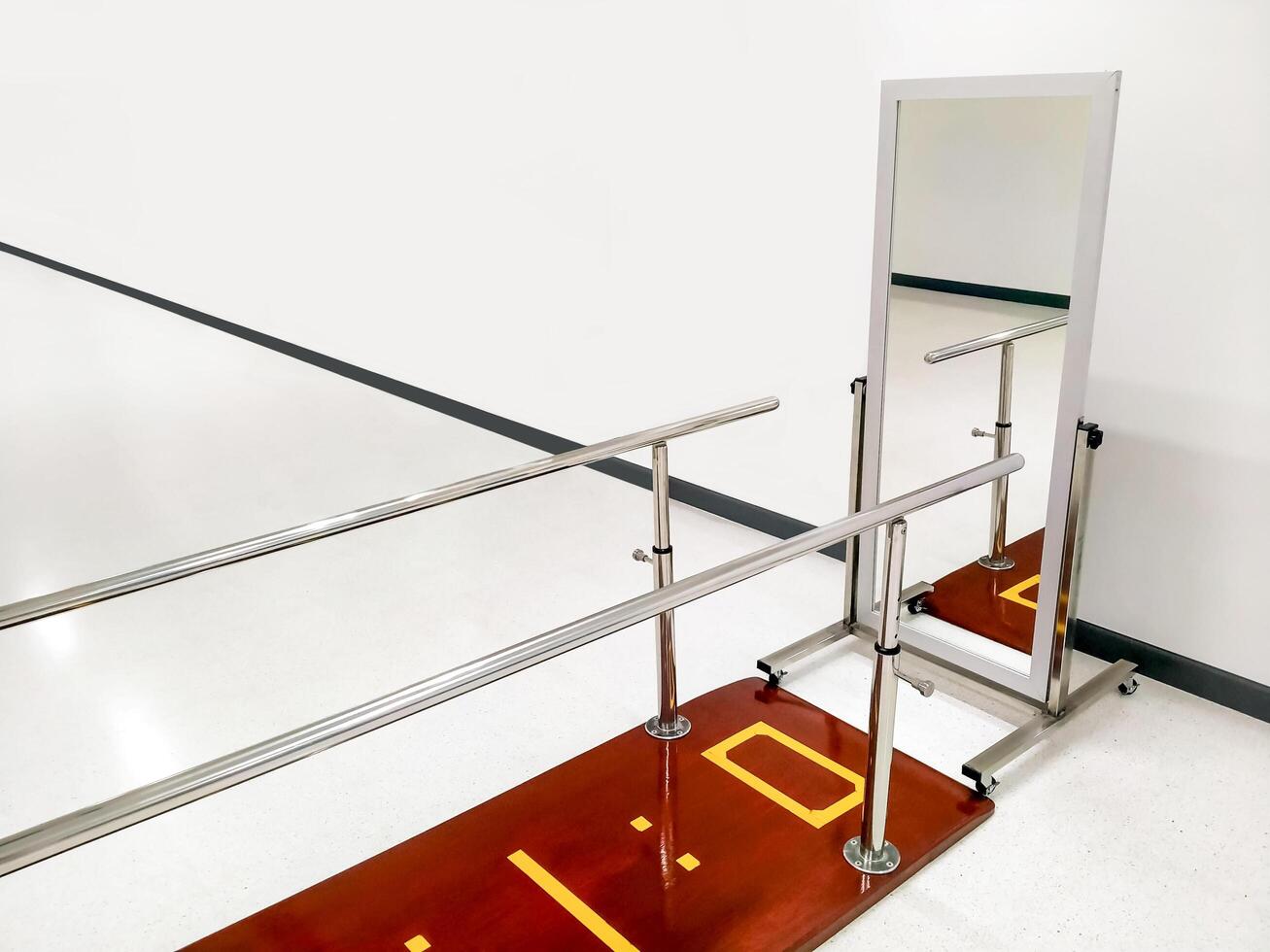 Rehab parallel bars with mirror in white room at rehabilitation center photo