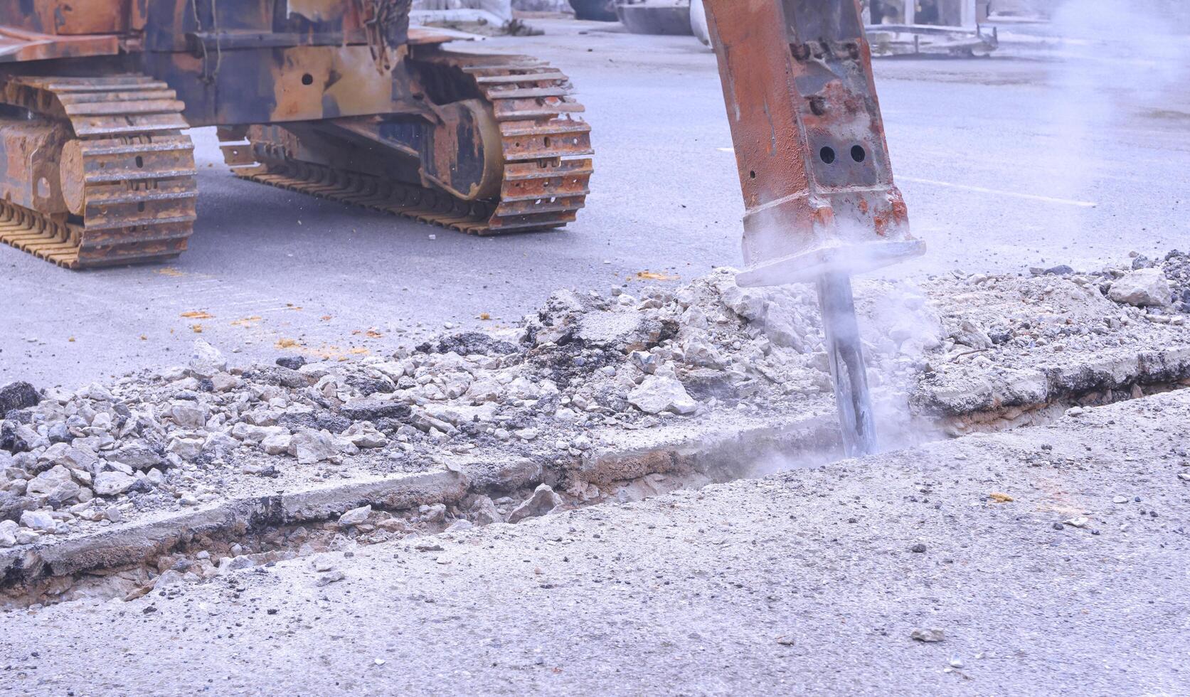 Excavator hydraulic crushing hammer is breaking asphalt road for preparing to install water piping system project photo