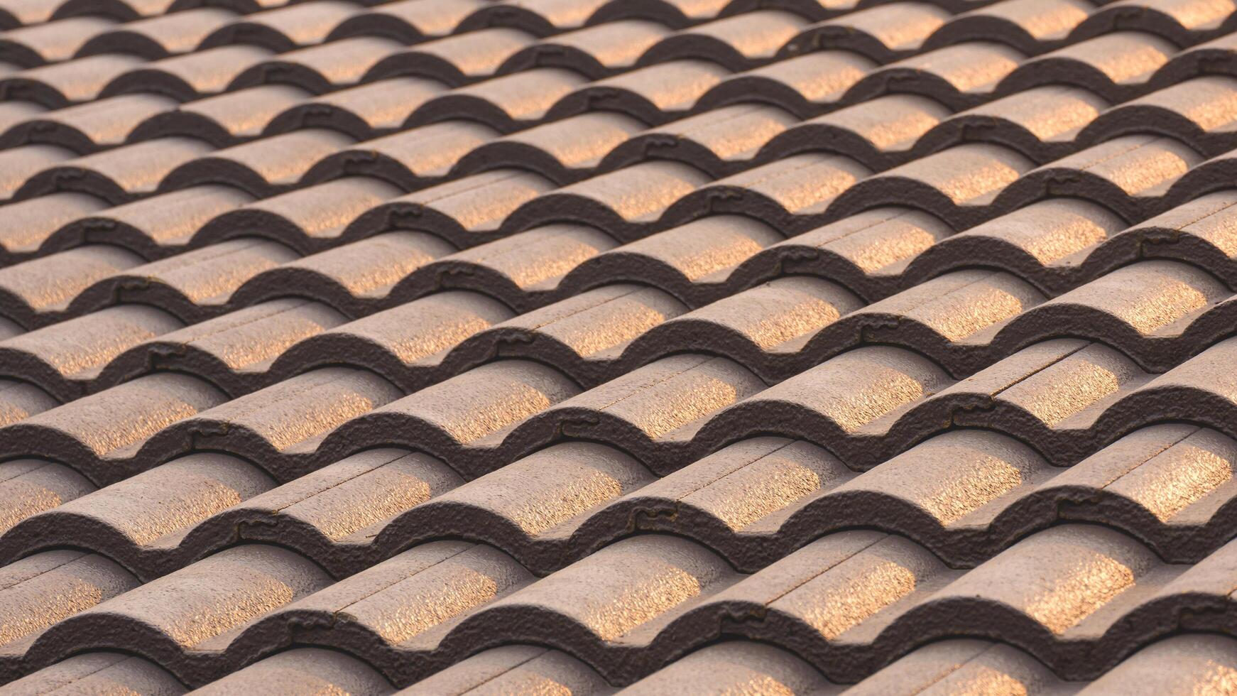 Background of gray concrete tiles roof pattern with golden sunlight reflection on surface photo