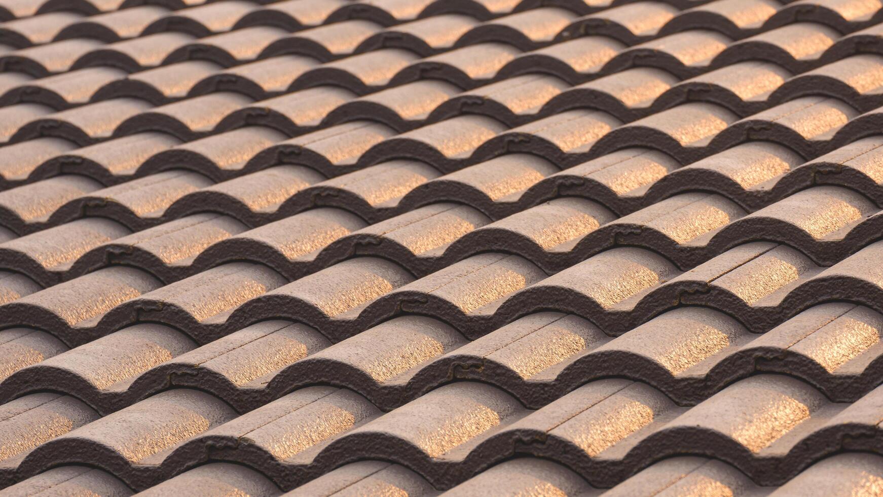 Background of gray concrete tiles roof pattern with golden sunlight reflection on surface photo