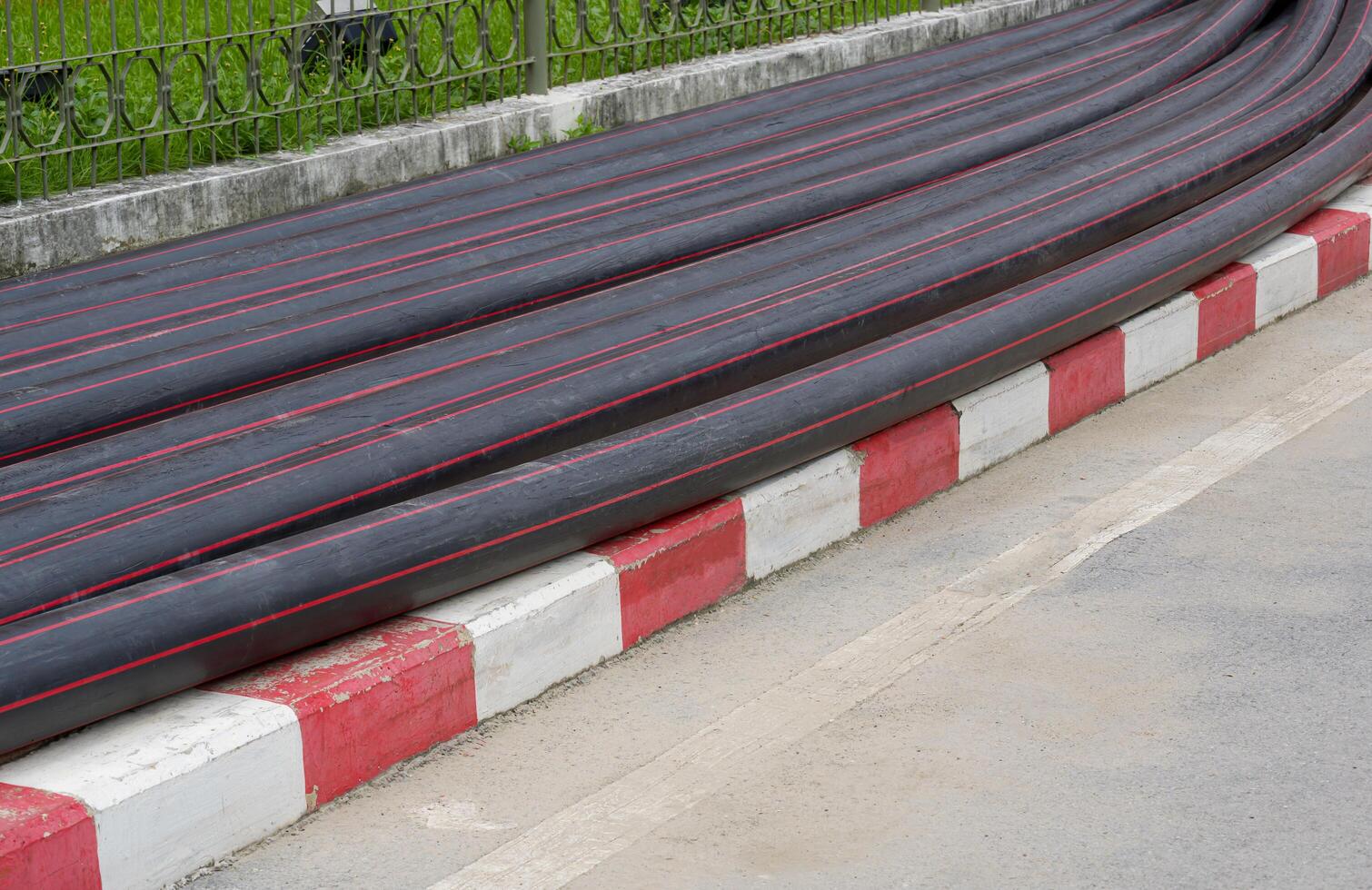 Pile of many HDPE pipes conduit on footpath for underground electrical wiring installation photo