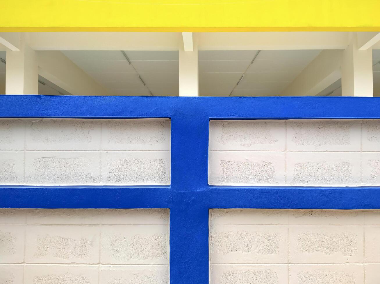 Background abstract blue and yellow line pattern of concrete block wall in front of white building photo
