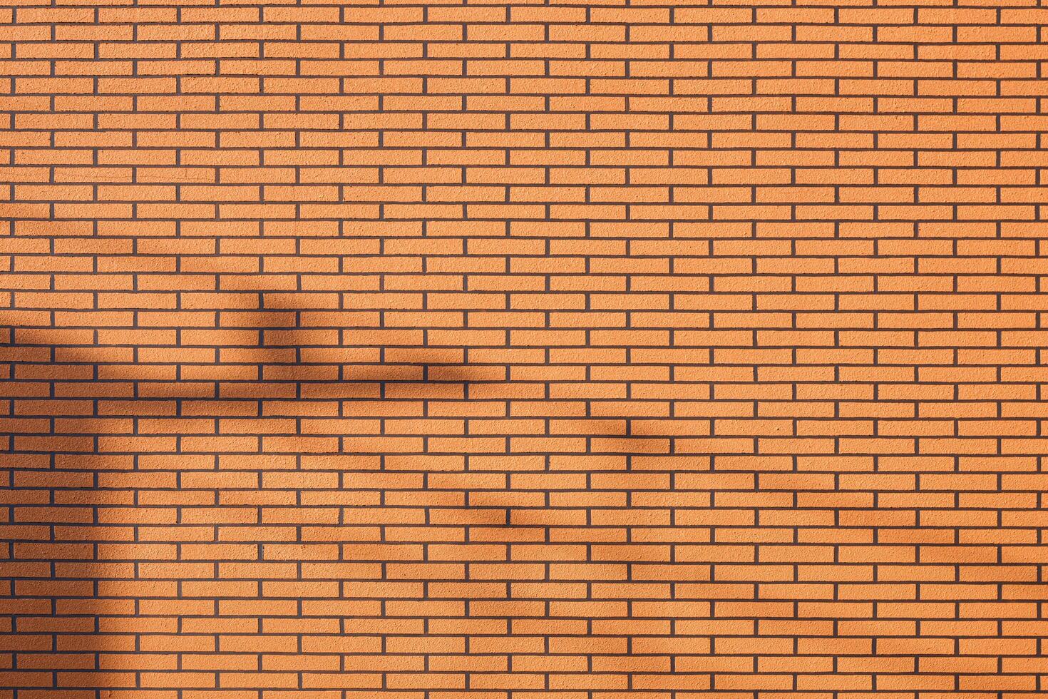 Artificial brick pattern background of insulation panel on decorative vintage building wall with sunlight and shadow on surface photo