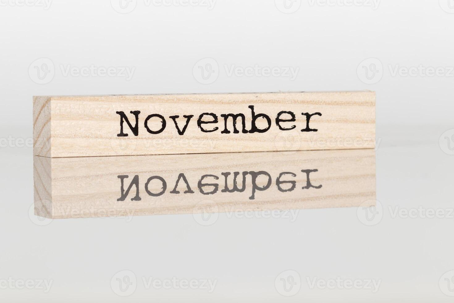 wooden cube with the inscription November on a white background photo