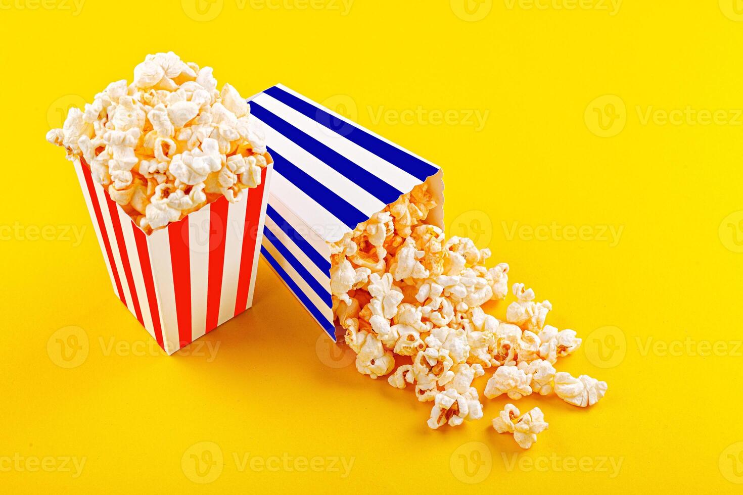 Glass with popcorn on a yellow background photo
