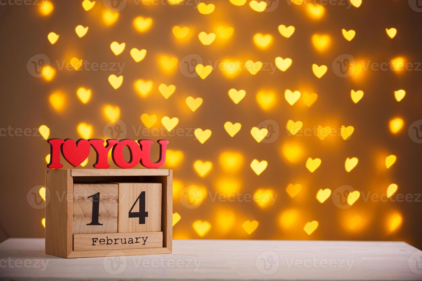 wooden calendar February 14 on a blurred background of hearts photo
