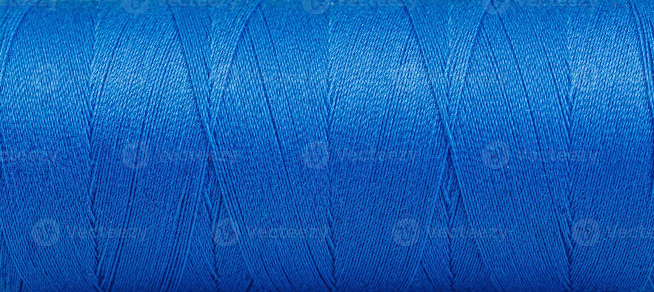 Texture of threads in a spool of blue color on a white background photo