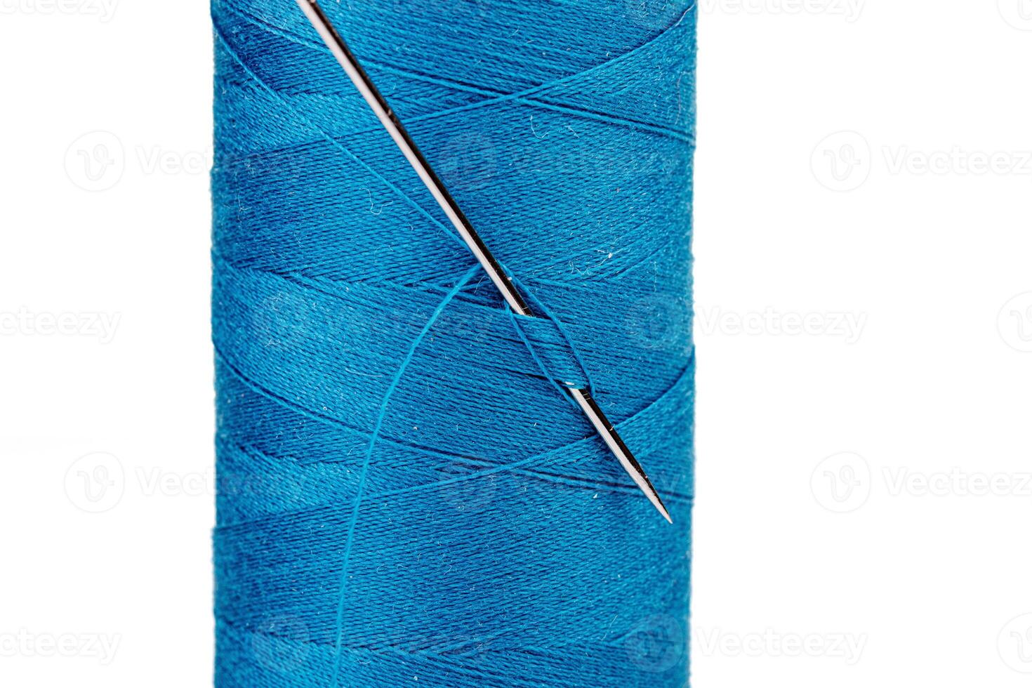 Macro skein of blue thread with a needle on a white background photo