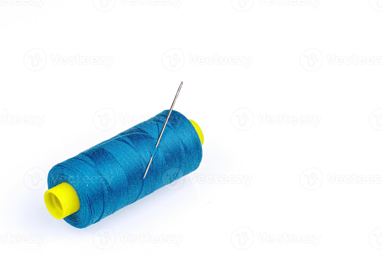 Macro skein of blue thread with a needle on a white background photo