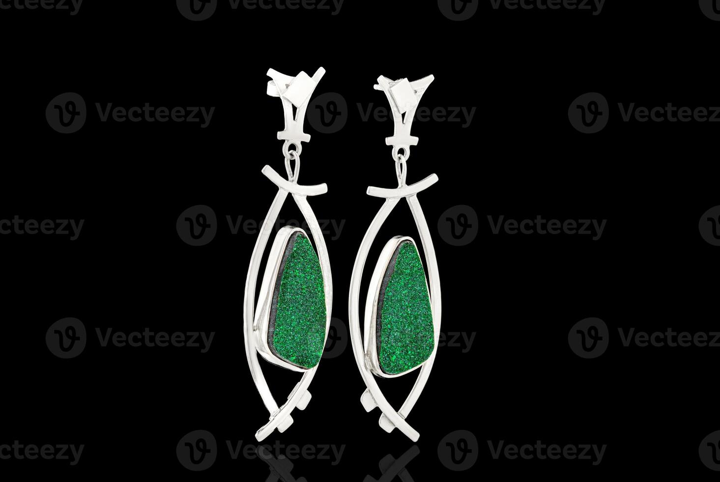 Beautiful gold, silver earrings with Uvarovite stone on a black background photo