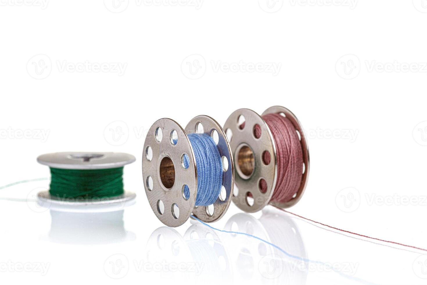 spools of blue and pink thread on a white background photo