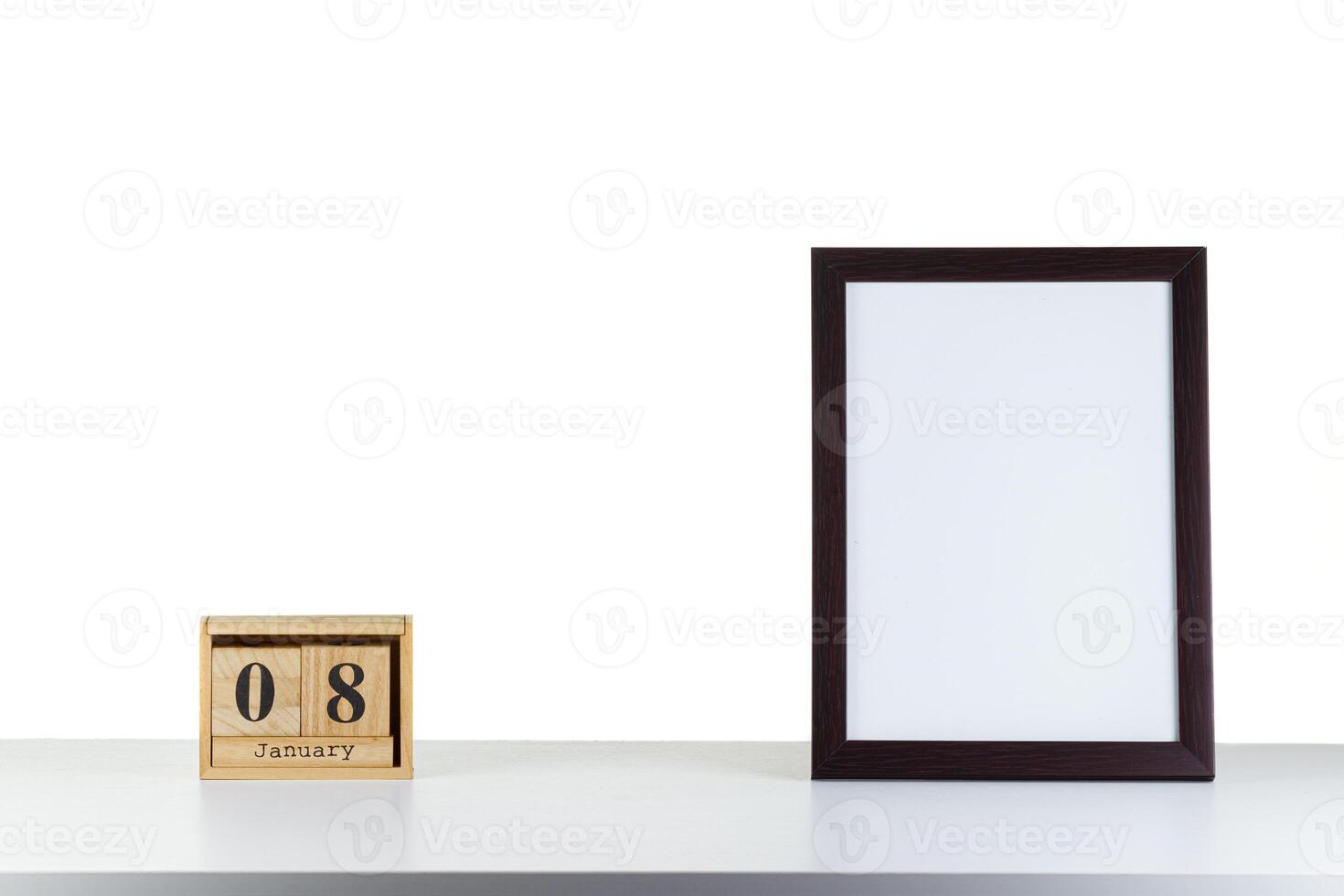 Wooden calendar 08 January with frame for photo on white table and background