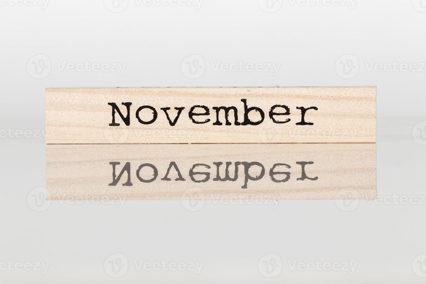 de madera cubo con el inscripción noviembre en un blanco antecedentes foto