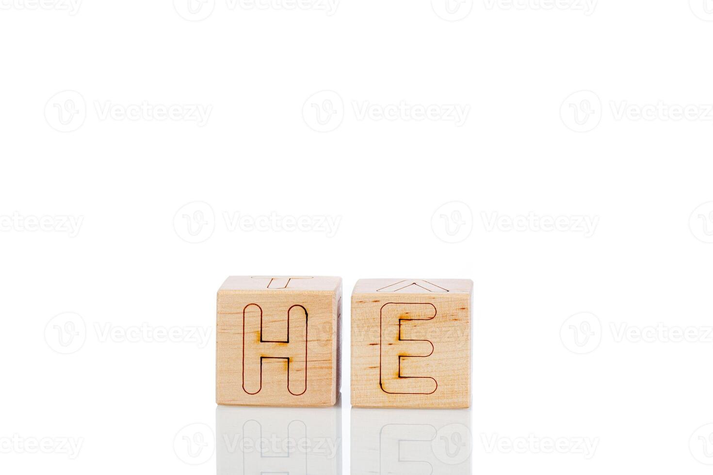 Wooden cubes with letters he on a white background photo