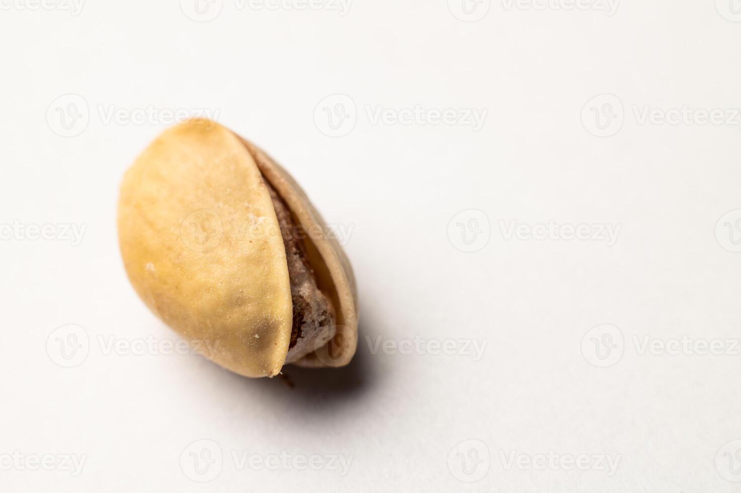 One pistachio nut on a white background, close-up photo