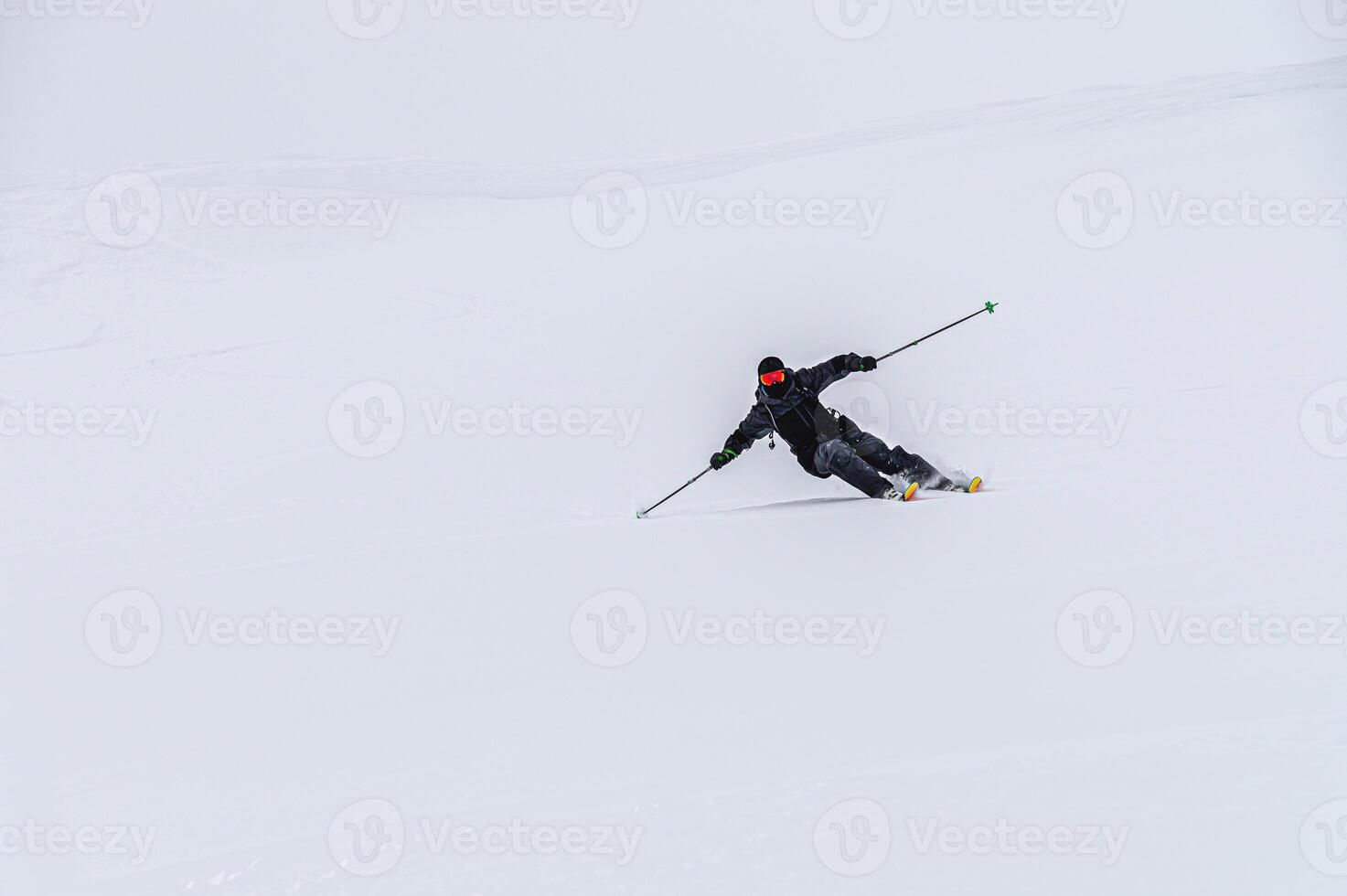 skier on the piste, going down the slope among the Alpine mountains, which are not visible due to cloudiness photo