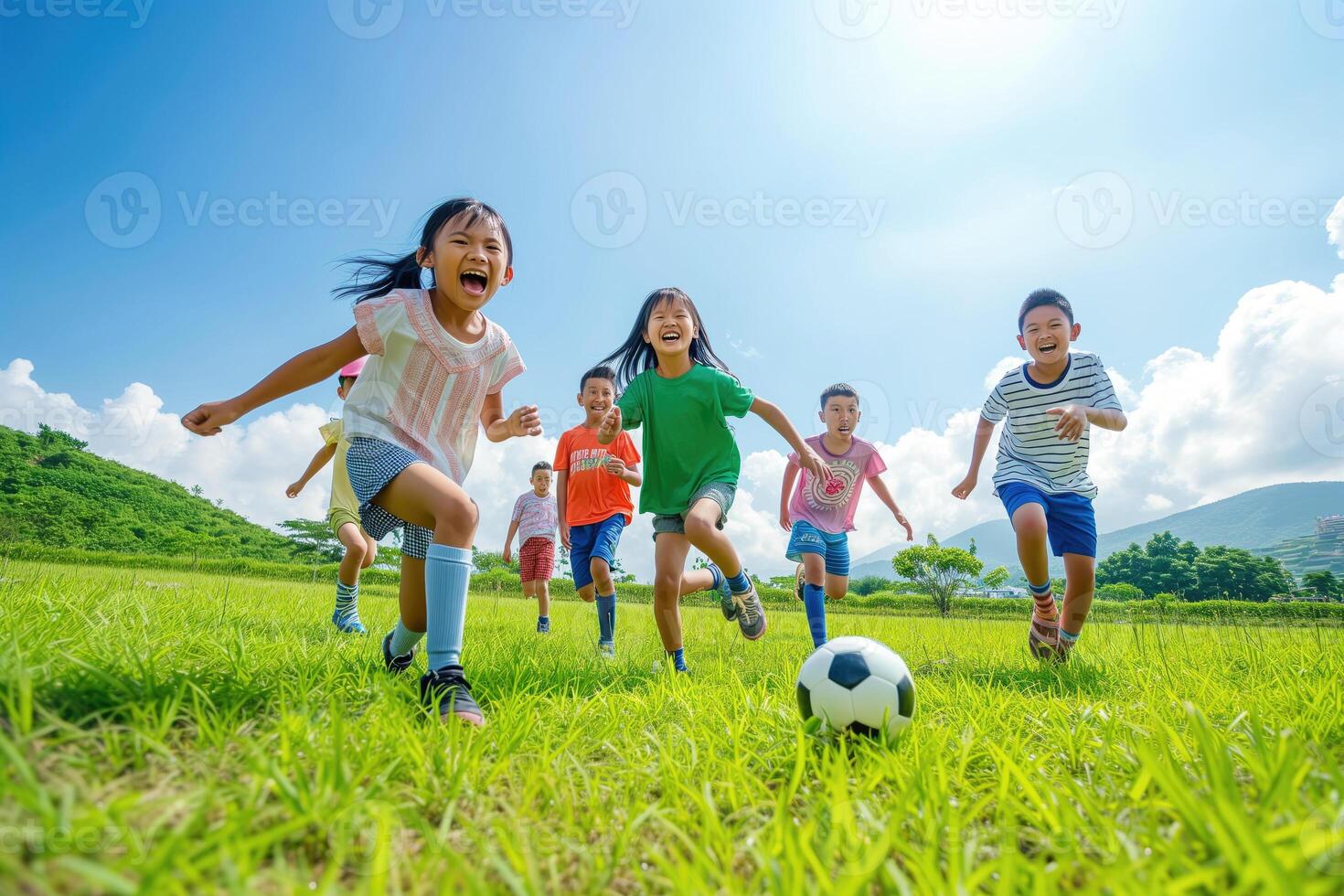 A group of Asian children playing soccer photo
