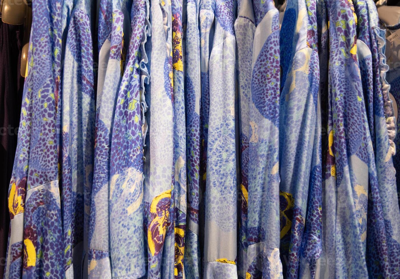 blue with yellow flowers summer blouses on a hanger in the store, bright clothes photo