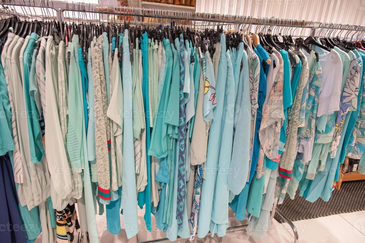 blue and white summer blouses on a hanger in the store, bright summer clothes photo