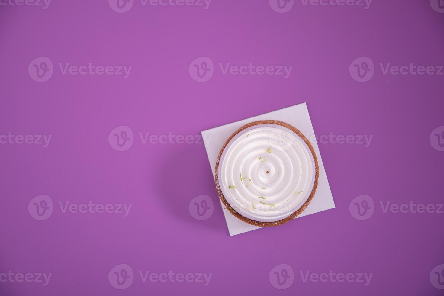 Mousse cake, top view, decorated with lavender flowers on a purple background photo
