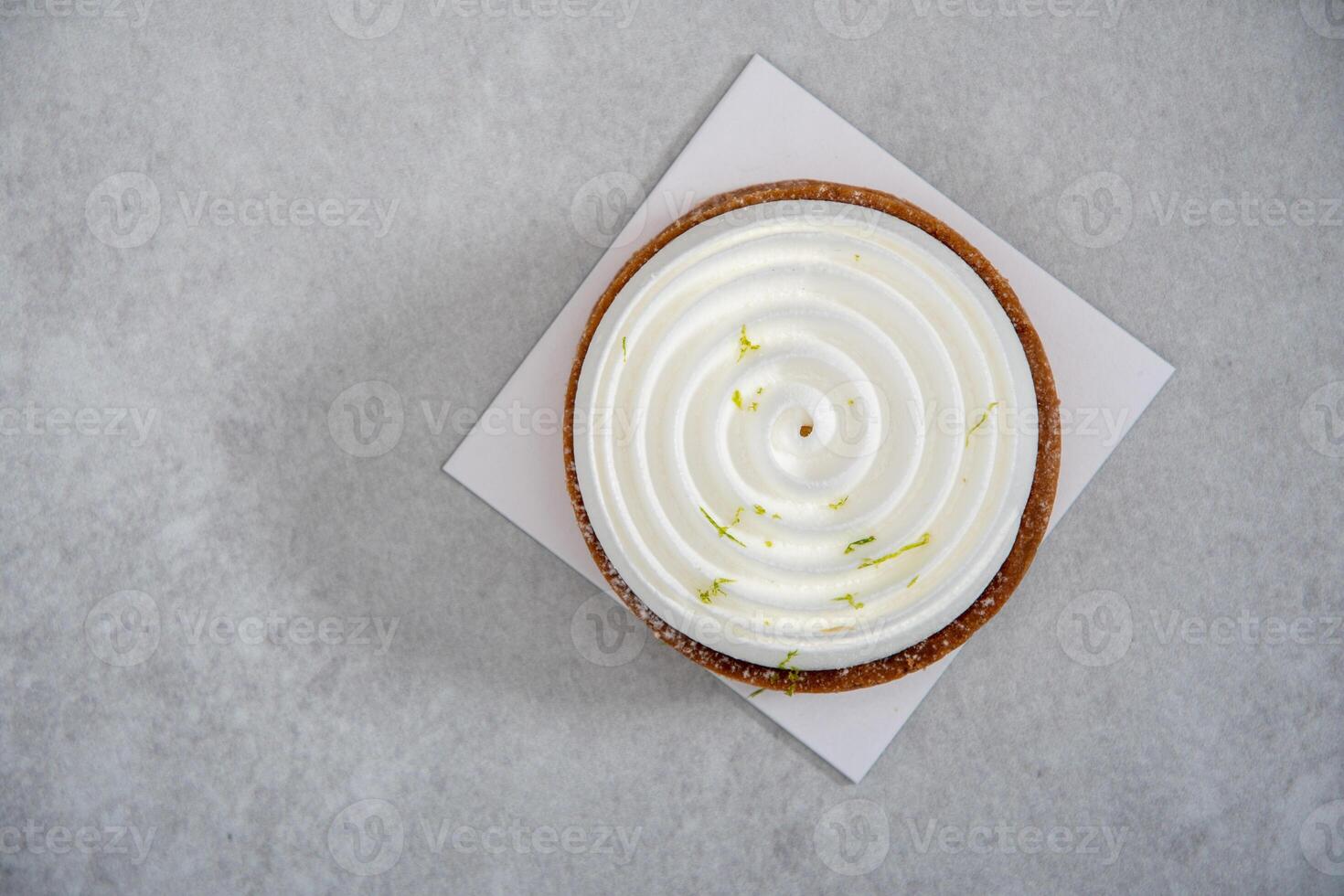 close-up mousse cake with snail decor on gray cement background top view photo