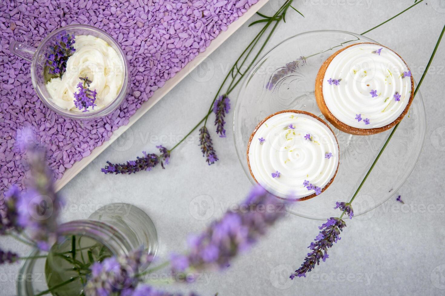 Two mousse cakes decorated with lavender flowers with cappuccino with cream photo