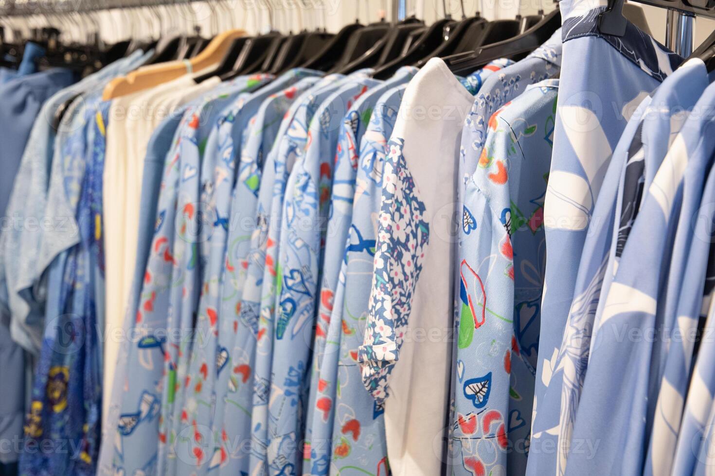blue and white summer blouses on a hanger in the store, bright summer clothes photo