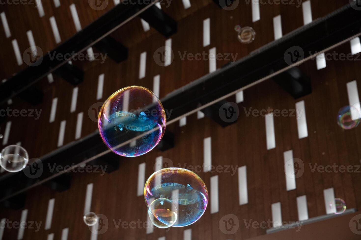 flying multicolored soap bubbles on a background of a roof with rectangular holes exotic background texture photo