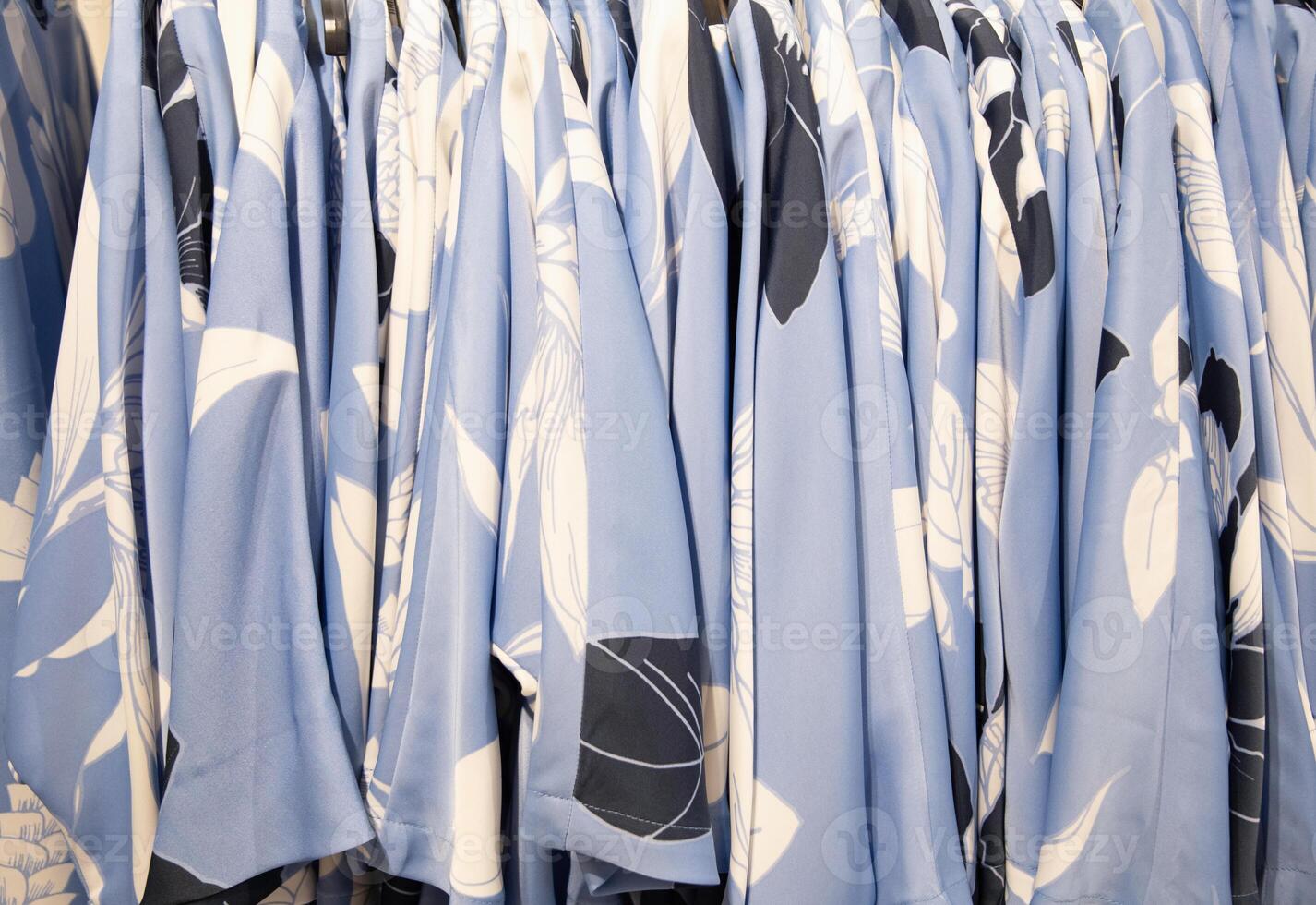 blue and white summer blouses on a hanger in the store, bright summer clothes photo