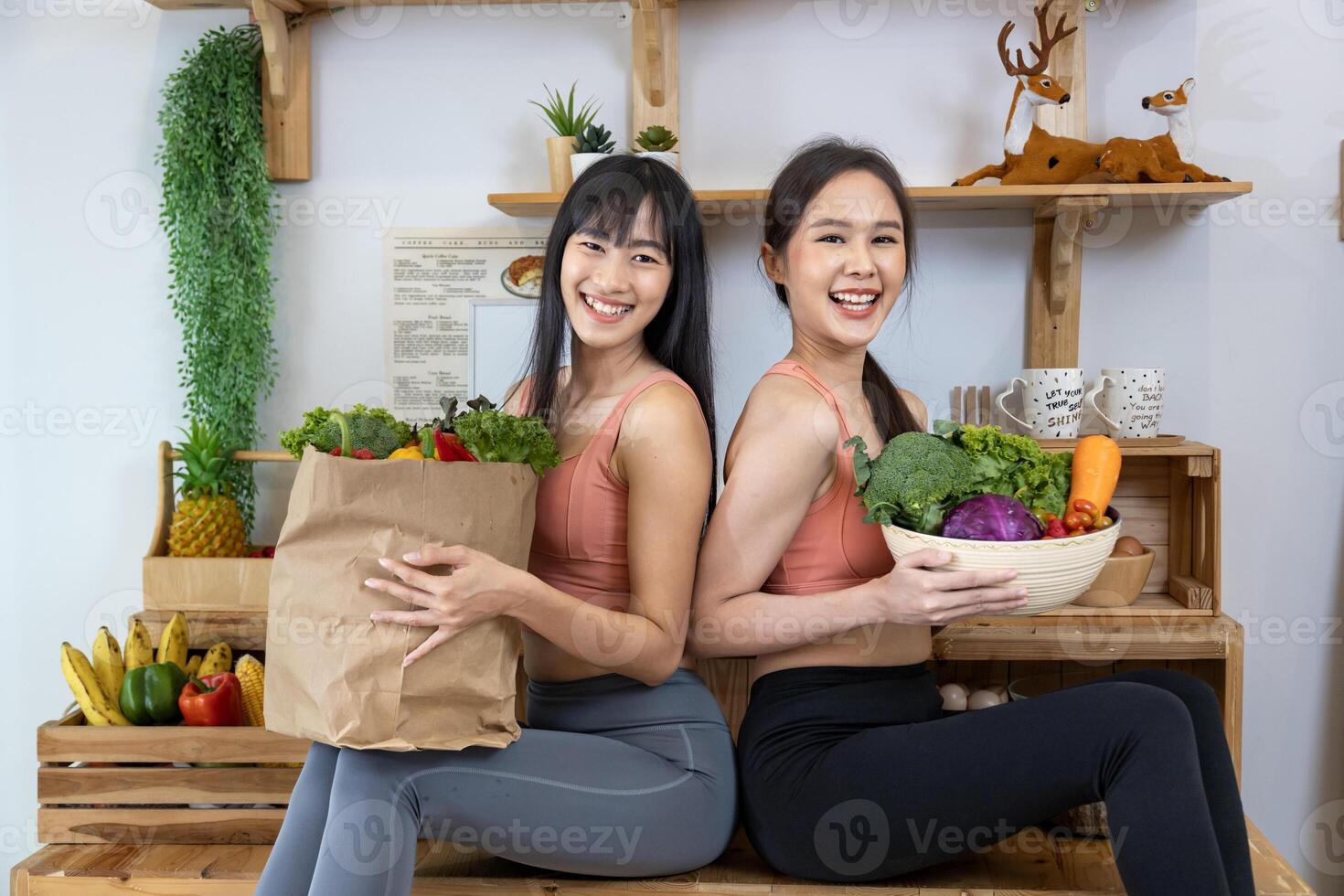 Asian sister is having a healthy food and drink while helping each other cooking in kitchen for vegan, vegetarian and plant based ingredients photo