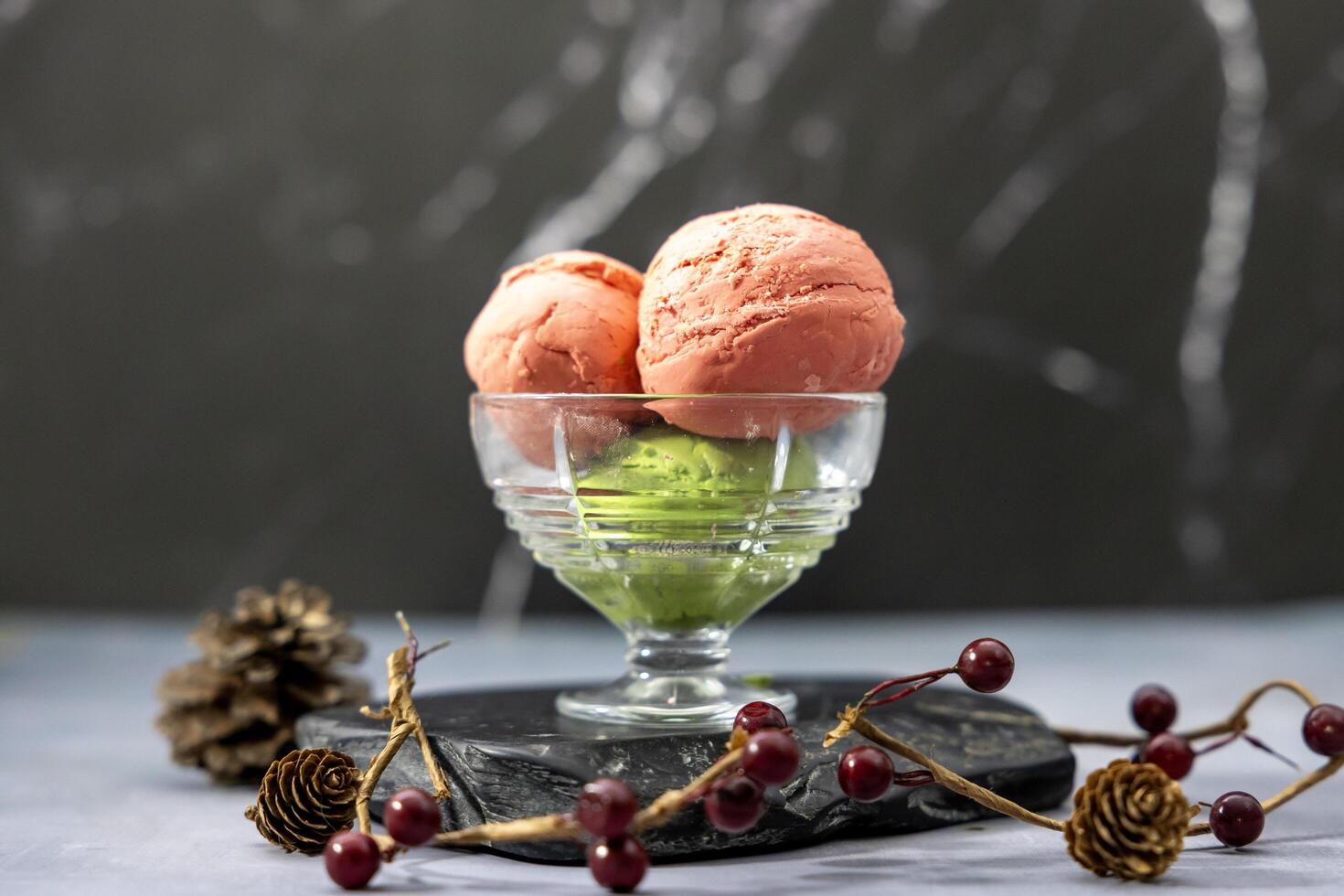 Strawberry and matcha green tea ice cream gelato with red berries and pine cone decoration for winter and christmas dessert concept photo