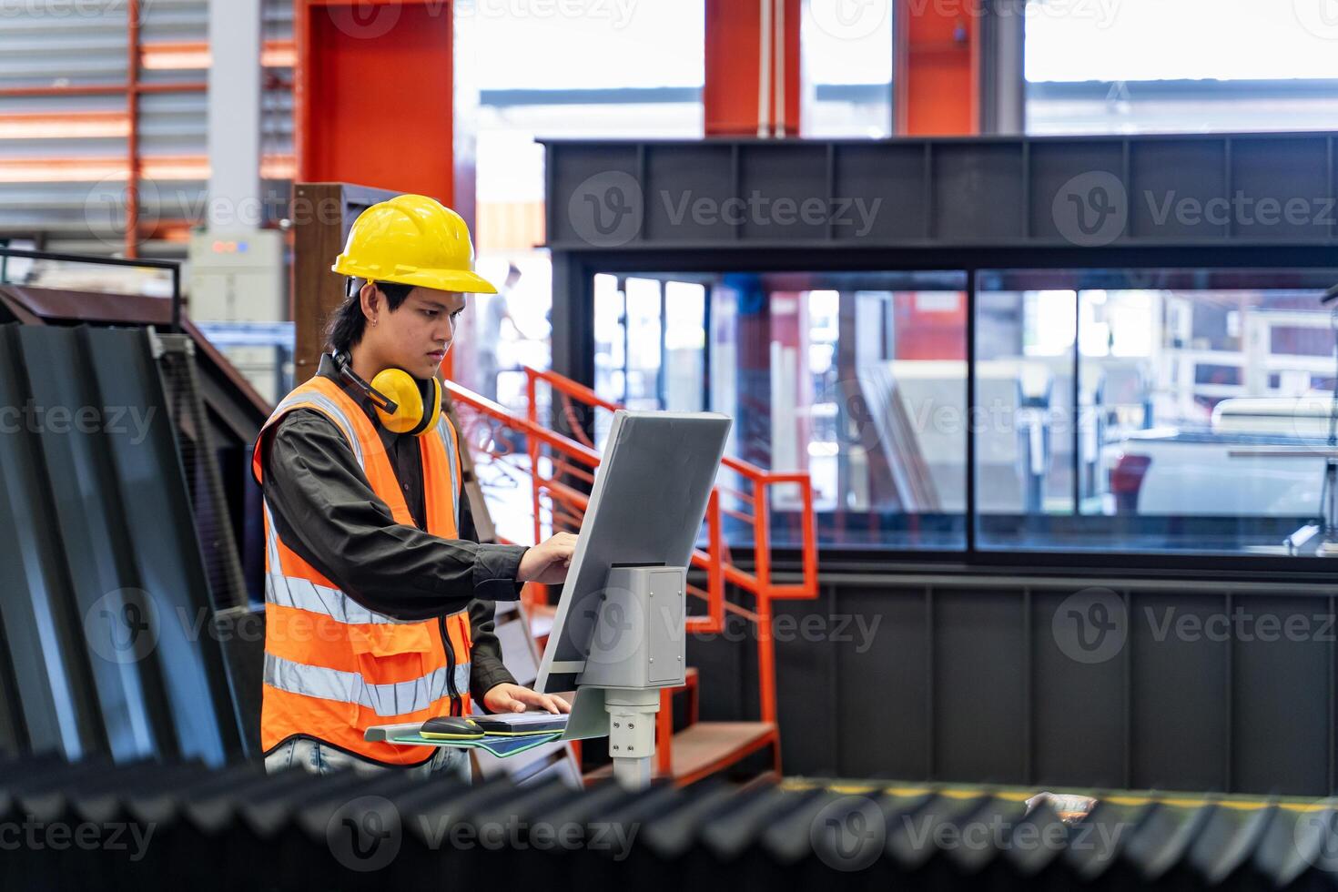 Engineering technician worker is operating the machine inside factory using touch screen computer monitor to command the order for line production and steel industry photo