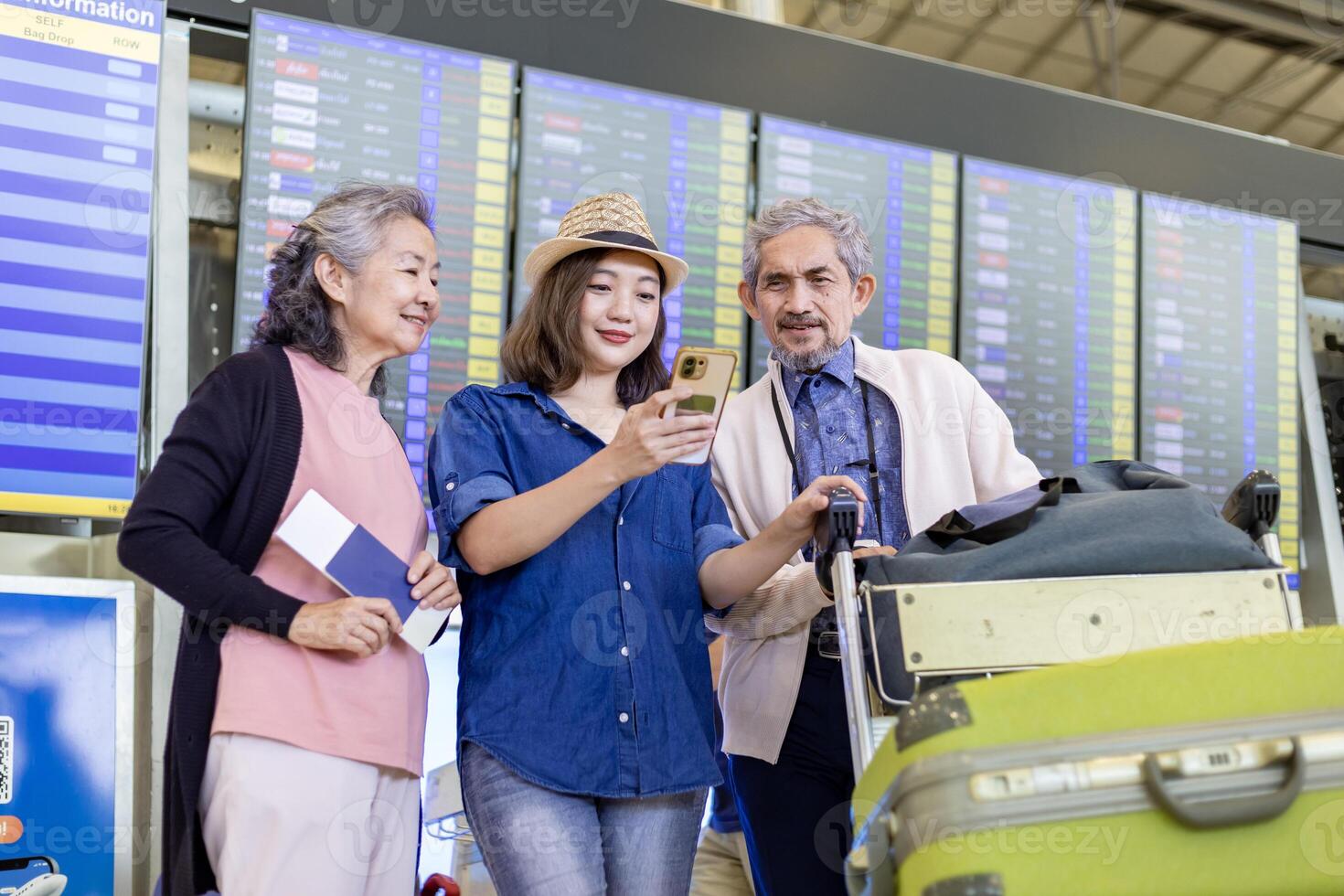 grupo de asiático familia turista pasajeros con mayor padre mirando a el salida mesa a aeropuerto terminal para aerolínea viaje y fiesta vacaciones foto