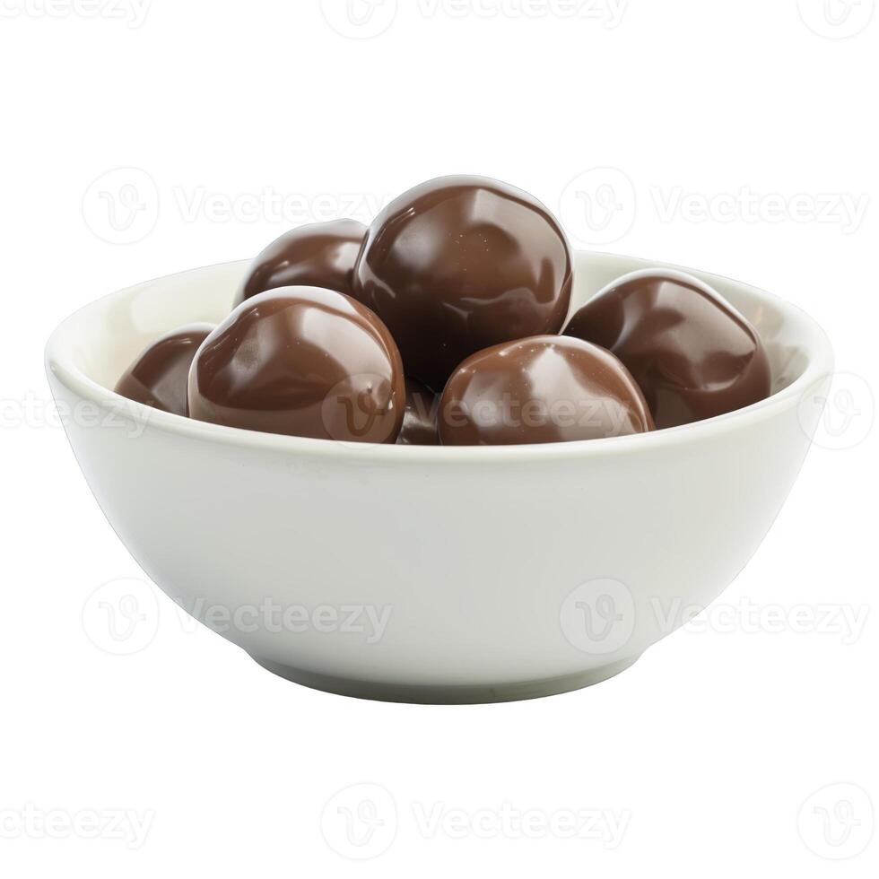 A bowl of chocolate candies sits on a white background. The candies are round and shiny. photo