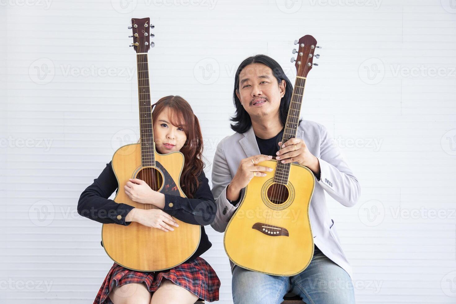 Portrait of Asian family duo band with two guitarist of father and daughter on white background for music, artist, musician style concept photo