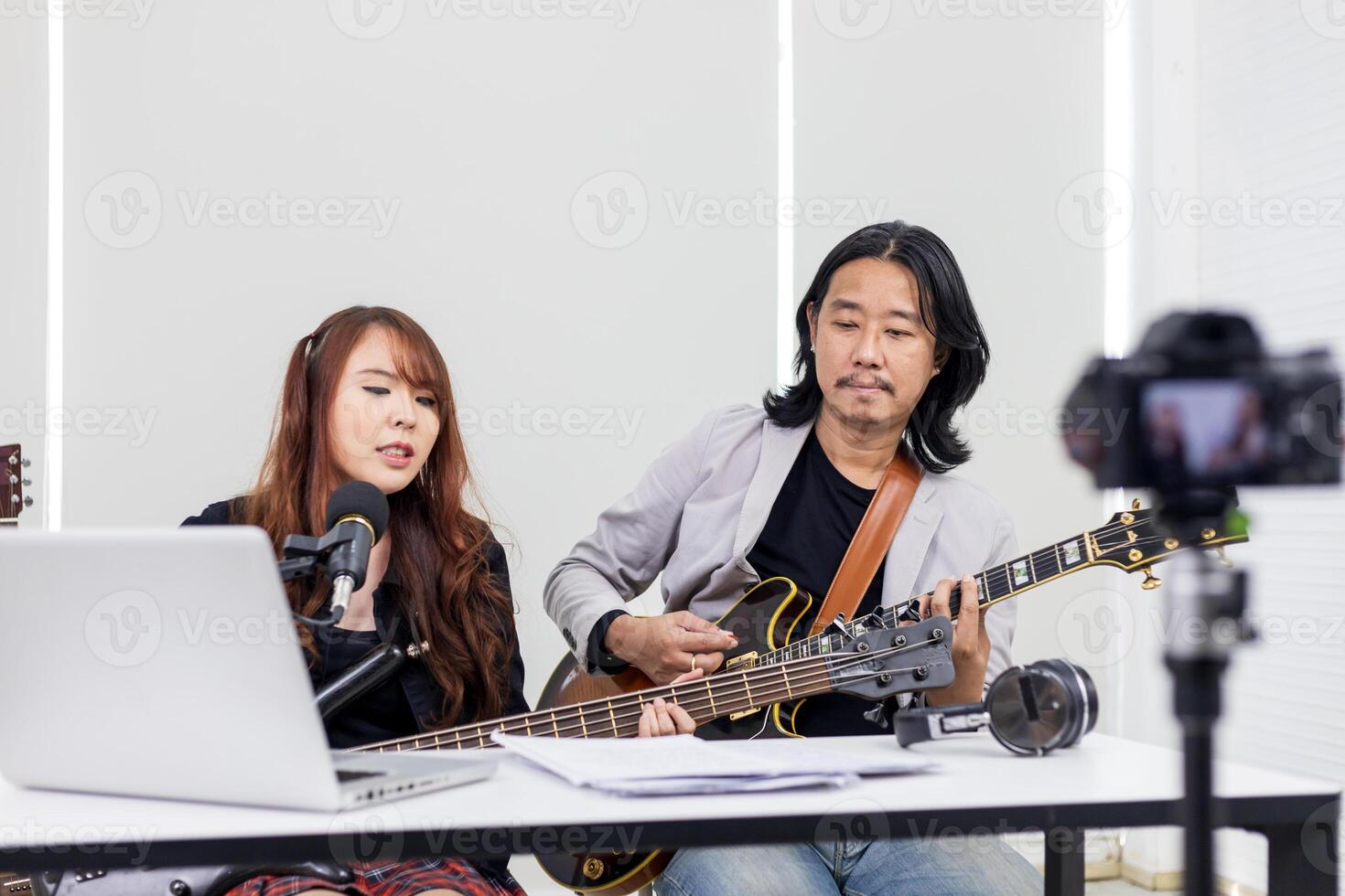 asiático músico ejecutando rock espectáculo En Vivo a hogar utilizando en línea plataforma para ventilador y audiencia a hogar concierto y transmisión transmitir red foto