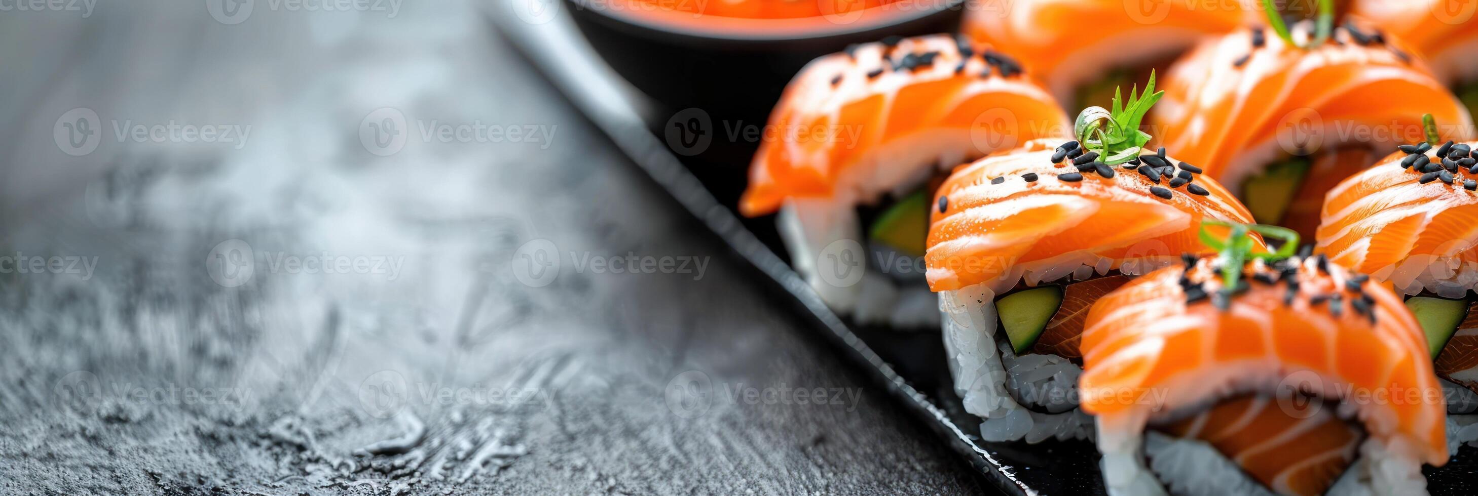 A black plate filled with sushi rolls and drizzled with savory sauce photo