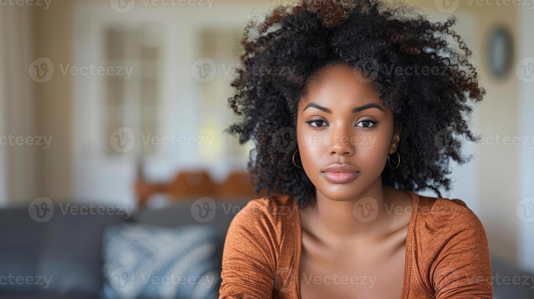 A woman sits on a couch in a modern living room decorated with a coffee table and plants photo