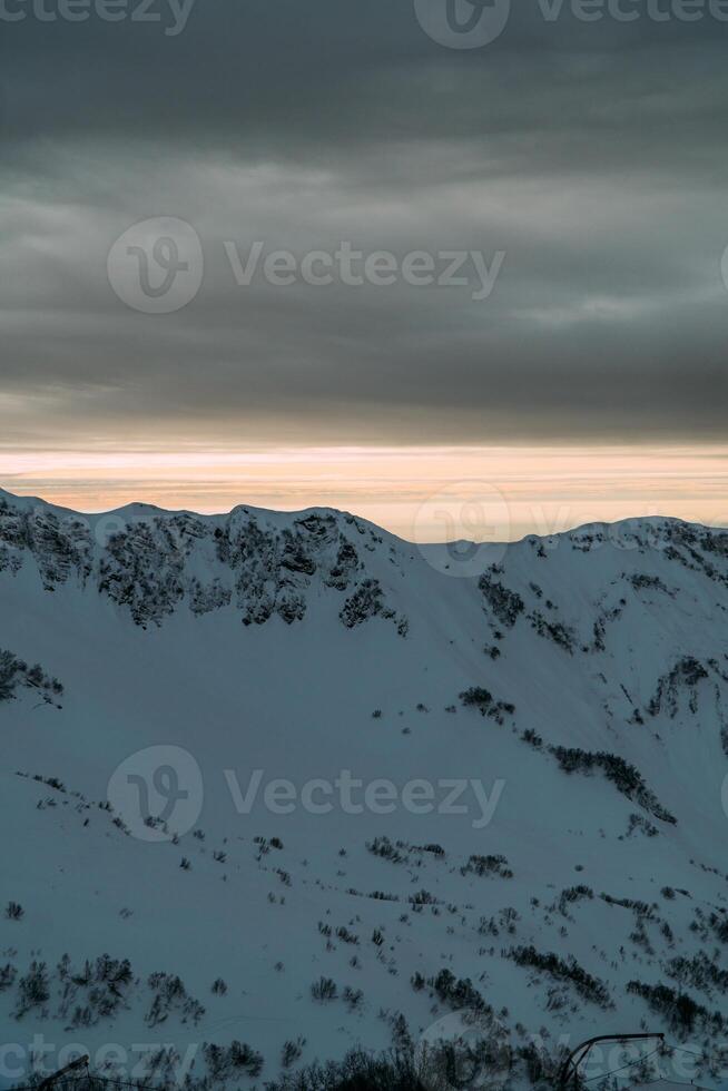 View of the winter sunset and snow-covered mountains photo
