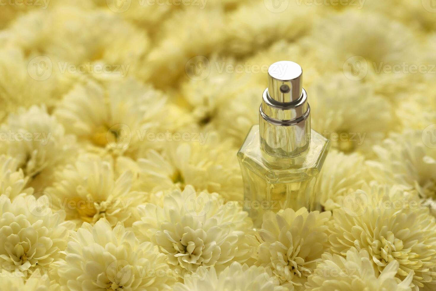 Women fragrance perfume bottle with flowers background close up. Unnamed blank sprayer bottle of perfume photo