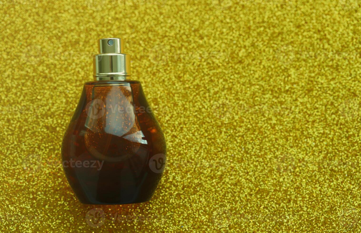 Women fragrance perfume bottle on yellow background close up. Unnamed blank sprayer bottle of perfume photo