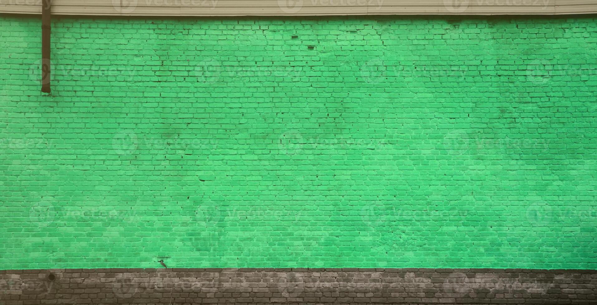 The texture of the brick wall of many rows of bricks painted in green color photo