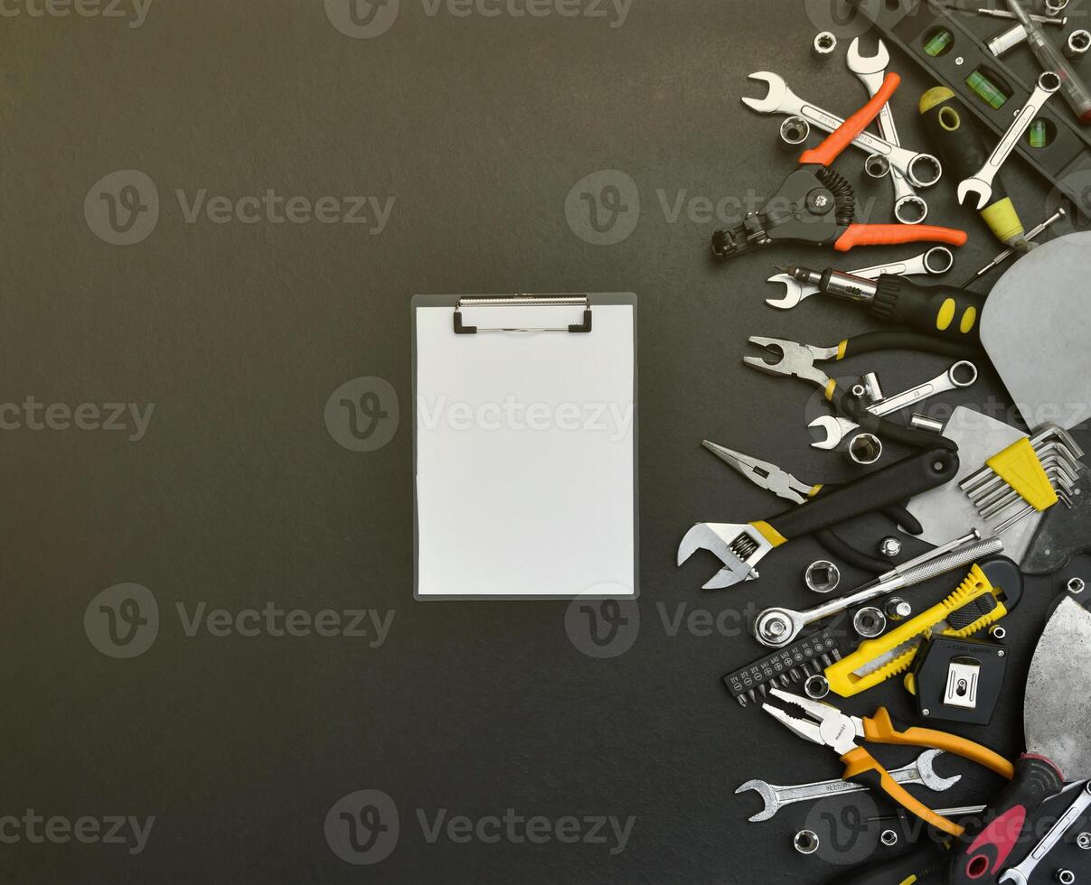Handyman tool kit on black wooden table. Many wrenches and screwdrivers, pilers and other tools for any types of repair or construction works. Repairman tools photo