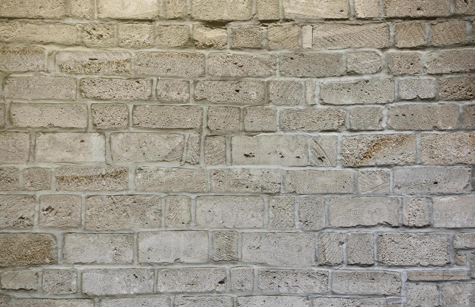 Very old brick stone wall of castle or fortress of 18th century. Full frame wall with obsolete dirty and cracked bricks photo