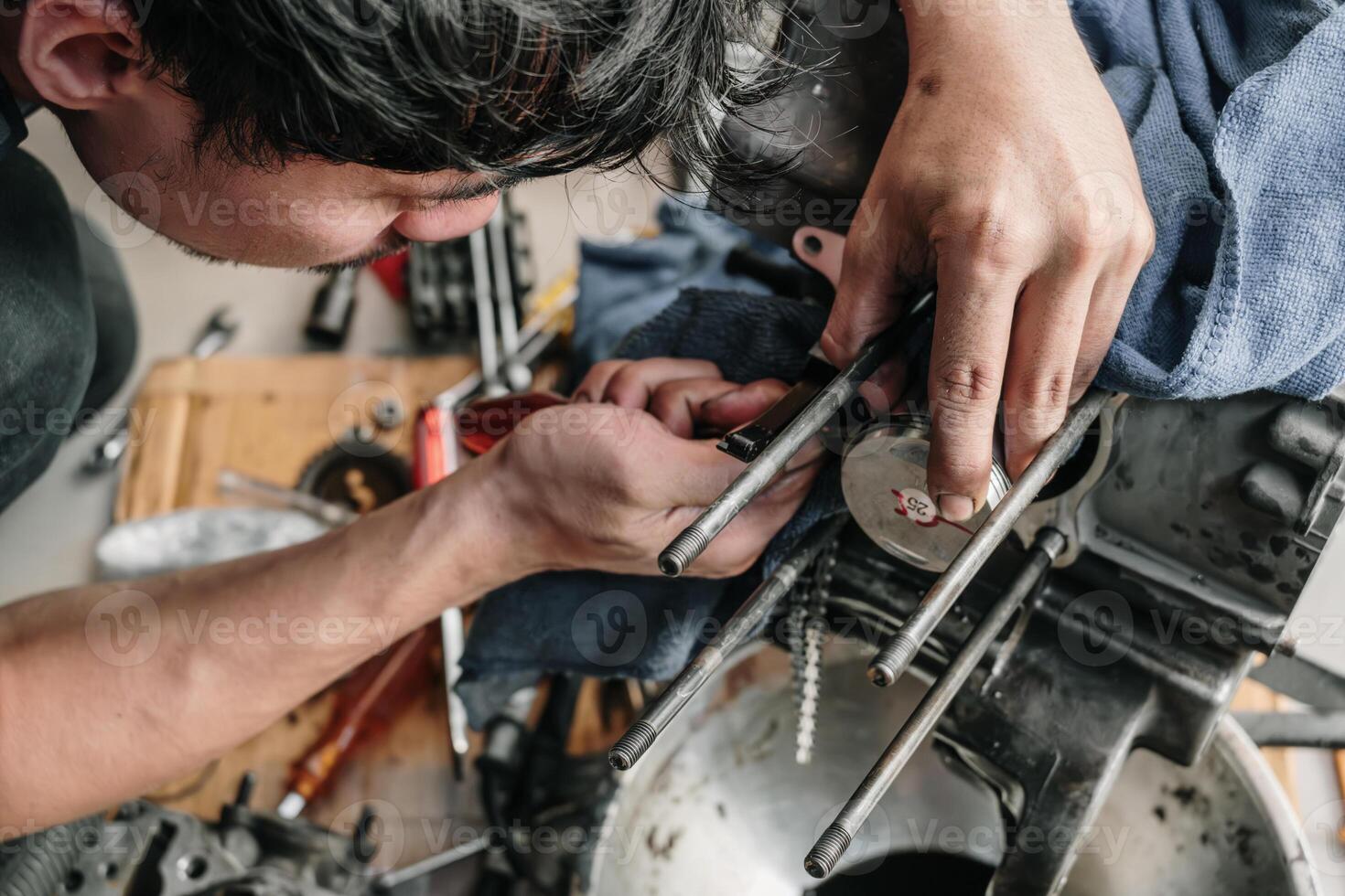 mecánico es instalando un motocicleta pistón en garaje.desmontaje y mantenimiento de motocicleta motor foto