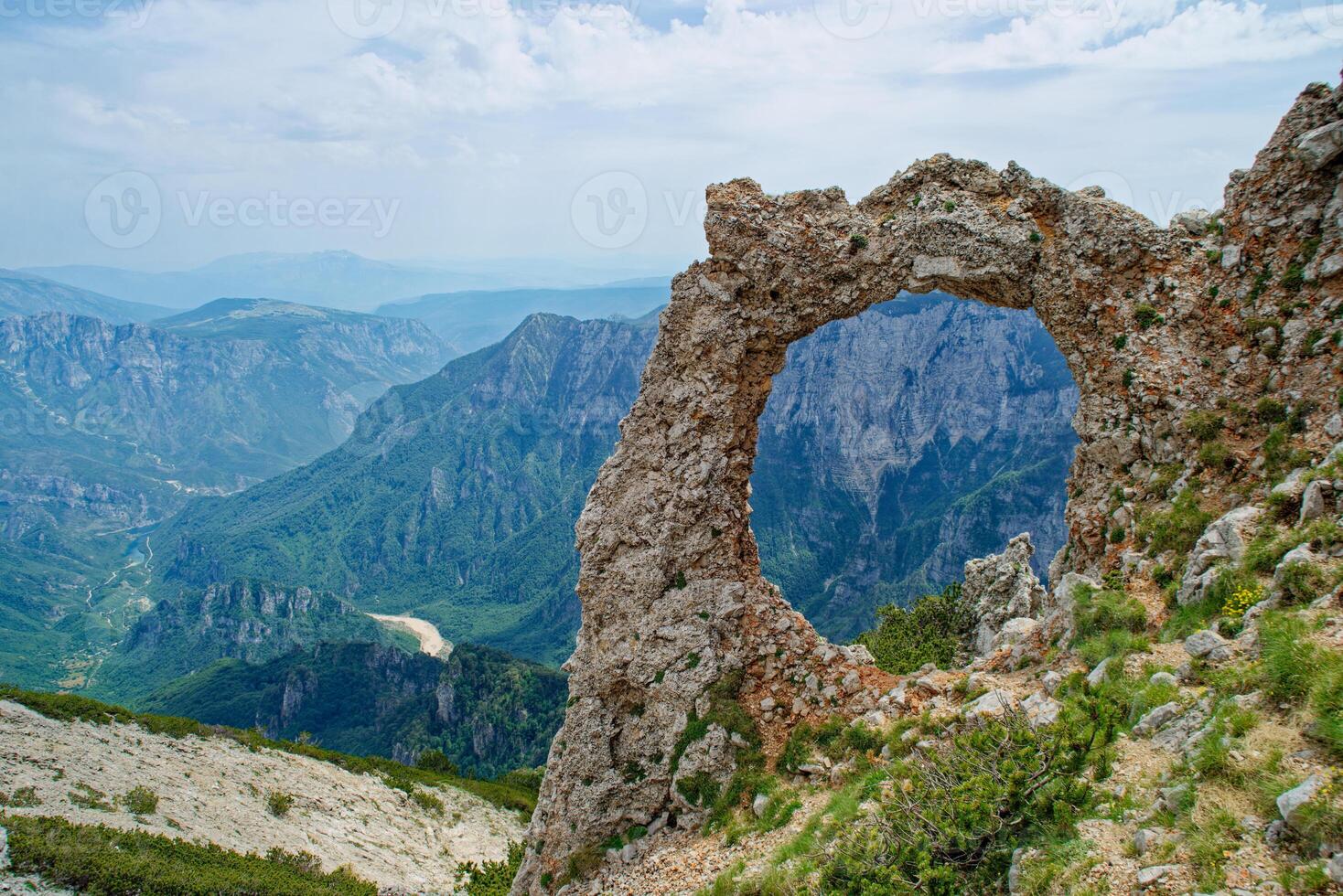 View of circular rock formation in the mountains. Natural monument Hajducka vrata in Cvrsnica mountain. Famous hiking place in Bosnia and Herzegovina. photo
